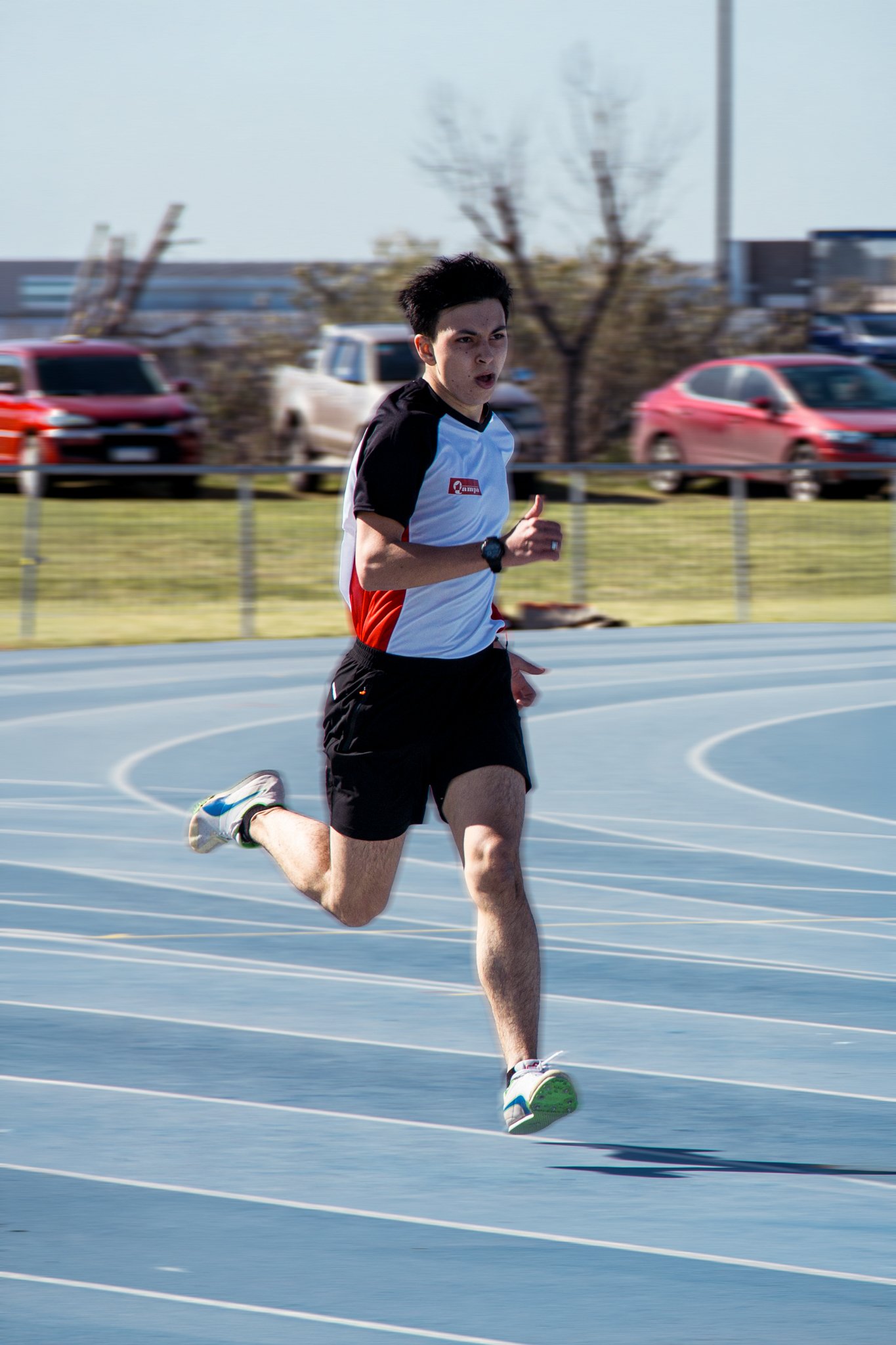 Atleta corriendo sobre una pista celeste