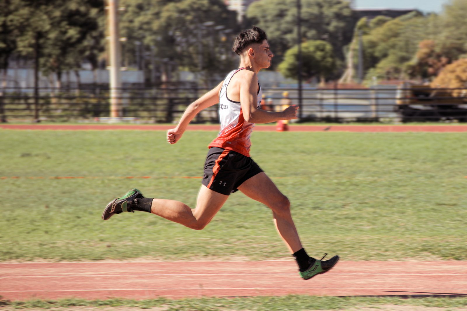 Atleta corriendo de perfil sobre la pista